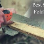 man using survival folding saw on piece of wood